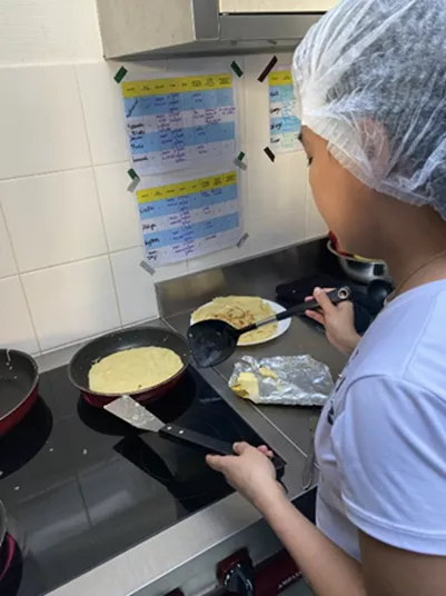 Jeune faisant des crêpes