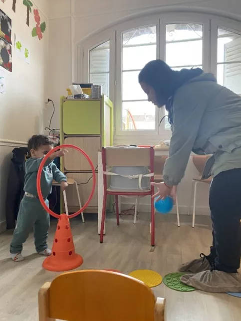Une maman et son fils jouent avec une balle et un cerceau